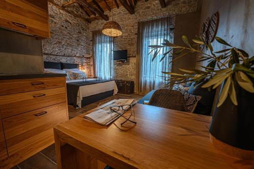 a room with a wooden table and a bedroom at Cleopatra's Miramare in Damouchari