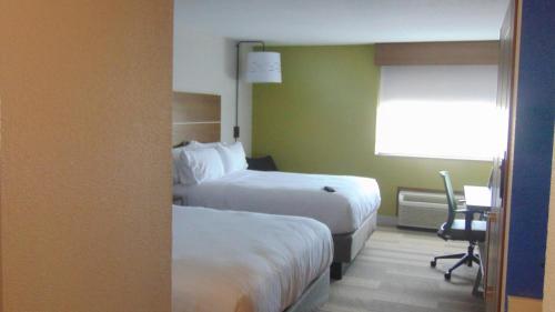 a hotel room with two beds and a desk at Holiday Inn Express & Suites Wapakoneta by IHG in Wapakoneta