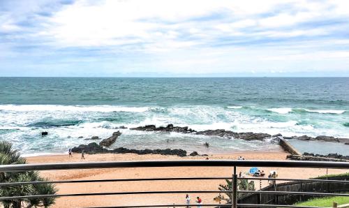 a view of the ocean with people on the beach at Palm Cove - 16 Chakas Cove, Literally on the Beach in Ballito