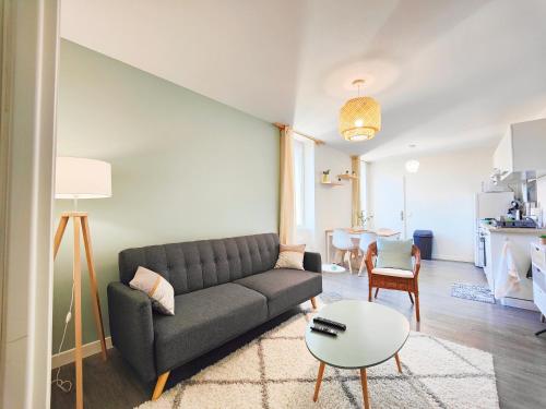 a living room with a couch and a table at Agréable T2 neuf -le DÔME- in Riom