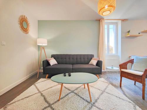 a living room with a couch and a table at Agréable T2 neuf -le DÔME- in Riom