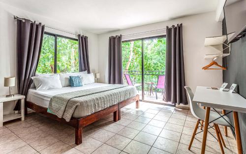 a bedroom with a bed and a balcony at Che Suites Playa in Playa del Carmen