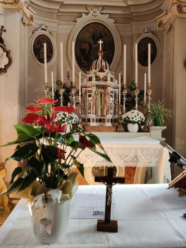 a altar with a vase of flowers on a table at Casa Zefìra in Feltre