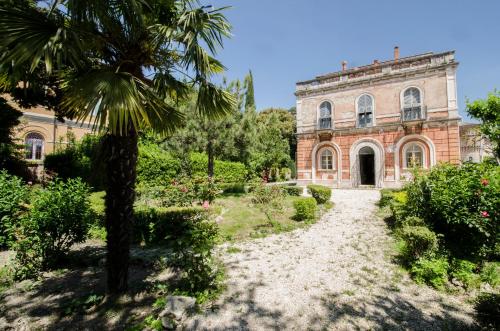 an old building with a palm tree in front of it at Hotel Iris in Perugia