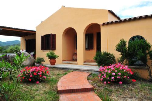 a house with flowers in front of a yard at Villa Geron in San Teodoro