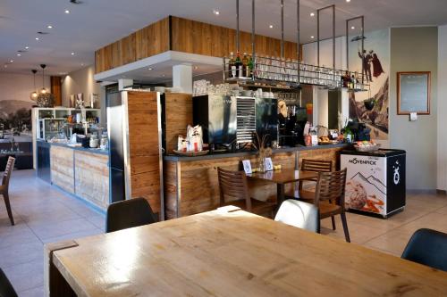 une salle à manger avec une table et une cuisine dans l'établissement Hôtel Oasis, à Moutier