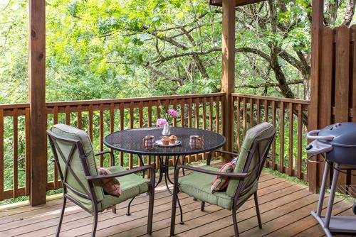 a patio with a table and chairs on a deck at Eureka Sunset Cabins in Eureka Springs