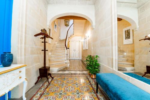 a hallway with a staircase and a blue couch at Monreal Boutique Townhouse - R024RM5 in Paola