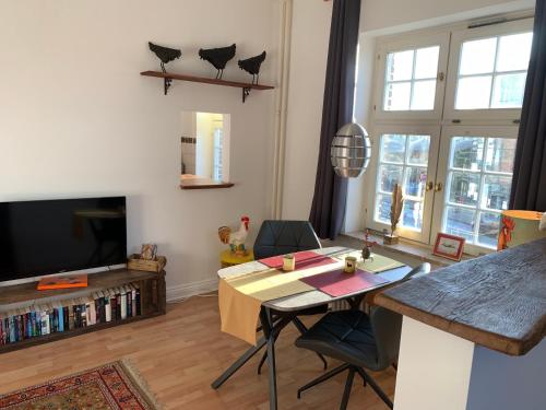 a living room with a table and a tv at trash de luxe in Schleswig