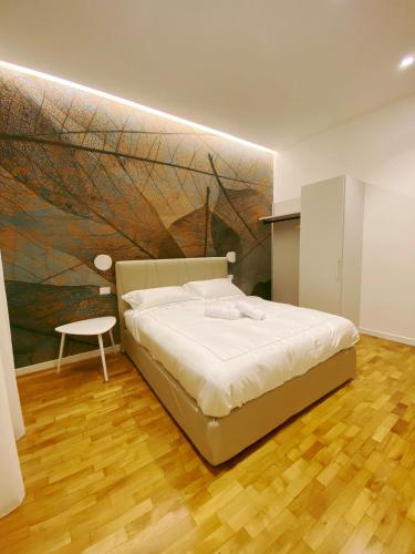 a bedroom with a bed and a painting on the wall at STAY home experience in Perugia