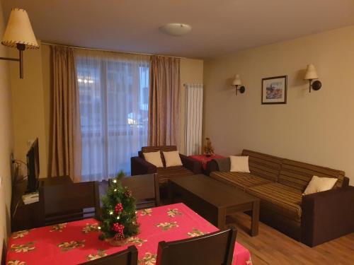 ein Wohnzimmer mit einem Weihnachtsbaum auf einem Tisch in der Unterkunft Dream Apart Hotel 207 in Bansko
