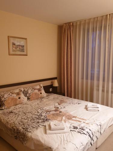 Schlafzimmer mit einem großen Bett und einem Fenster in der Unterkunft Dream Apart Hotel 207 in Bansko