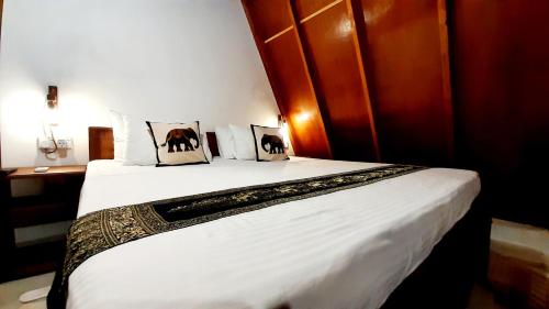 a bedroom with a bed with two pillows on it at The Otunna Guest House Sigiriya in Sigiriya