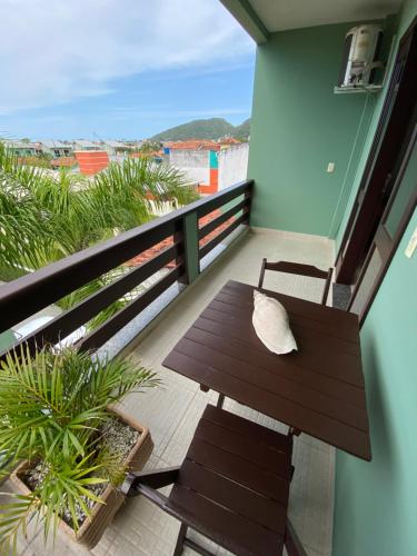 a balcony with a bench and a view of the beach at Canto Leste Pousada in Florianópolis