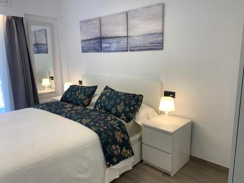 1 dormitorio con 1 cama y mesita de noche con lámpara en Formentor, en Castelldefels