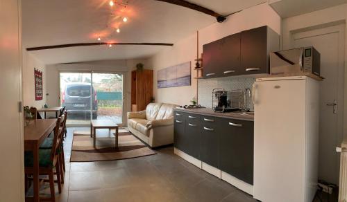 une cuisine avec un réfrigérateur et un salon dans l'établissement Ravissante suite avec parking sur place., à Pessac