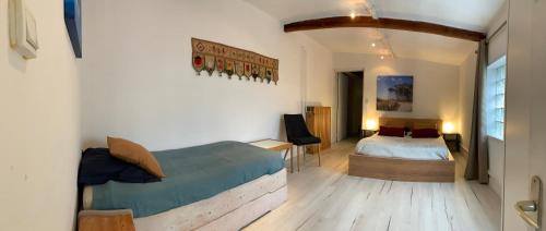 ein Schlafzimmer mit einem Bett und einem Schreibtisch in einem Zimmer in der Unterkunft Ravissante suite avec parking sur place. in Pessac