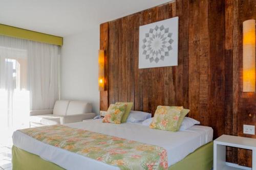 una camera d'albergo con due letti e un divano di Búzios Beach Resort Luxo a Búzios