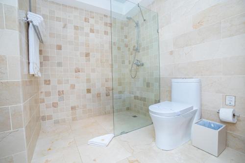 a bathroom with a toilet and a glass shower at Presidential Suites Cabarete - Room Only in Cabarete
