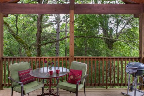 a patio with a table and chairs on a porch at Eureka Sunset Cabins in Eureka Springs