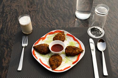 a plate of food with meat and sauce on a table at Little Affair in Tehla