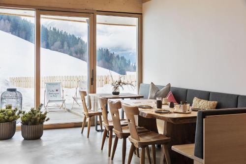 a dining room with a table and chairs and a large window at Holzhackerin - the charming Haus am Berg in Schladming