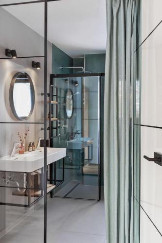 a bathroom with a sink and a glass shower at Holzhackerin - the charming Haus am Berg in Schladming