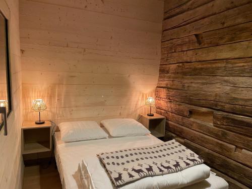ein Schlafzimmer mit einem Bett und zwei Lampen an zwei Tischen in der Unterkunft La Grange d'Anaïs in Beaufort