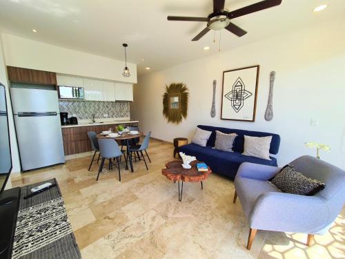 sala de estar con sofá azul y cocina en Comfortable apartment near the beach., en Playa del Carmen