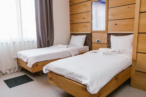 two beds in a room with wooden walls at Rtanj Kopaonik Eco Resort & Spa in Kopaonik