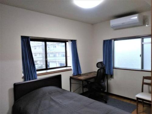um quarto com uma cama, uma secretária e 2 janelas em Maison Ota Building A Building B - Vacation STAY 12386 em Takamatsu