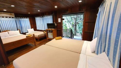 Un pat sau paturi într-o cameră la Baansuan Lychee Maeklong Resort Ampawa