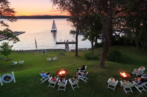 a group of people sitting in chairs on a lawn with fires at Silver Birches Resort in Hawley