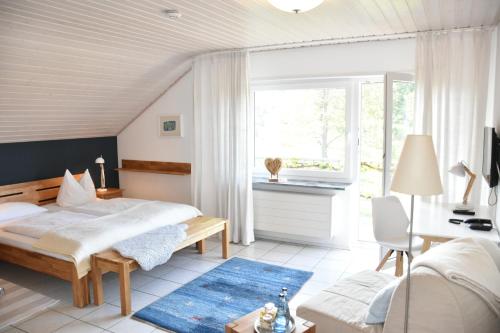 Schlafzimmer mit einem Bett, einem Schreibtisch und einem Fenster in der Unterkunft Hotel KAMPS in Sinsheim