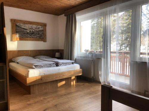 um quarto com uma cama e uma grande janela em Karwendel-Lodge em Scharnitz