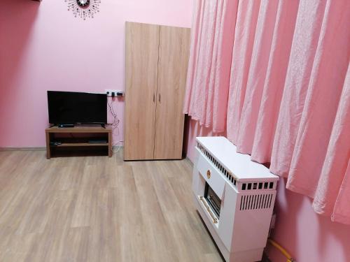 ブダペストにあるKeleti Apartmentsのリビングルーム(テレビ、ピンクのカーテン付)