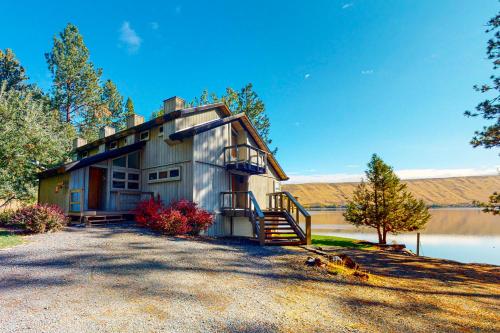 a house with a staircase next to a body of water at Meadowlark in Joseph