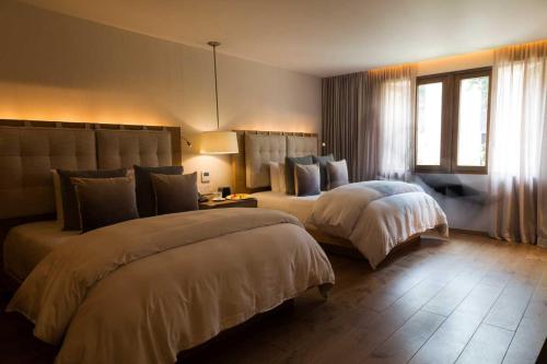 a hotel room with two beds and a window at Cartesiano Boutique & Wellness Hotel in Puebla