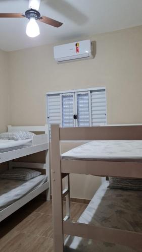 a room with two bunk beds and a ceiling fan at Pelourinho in Olímpia