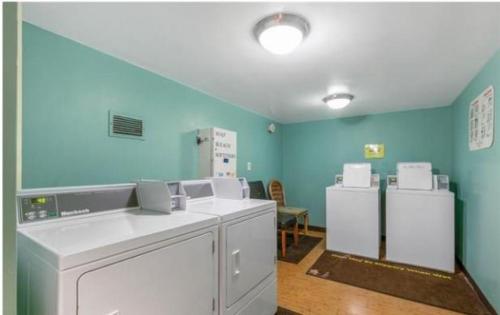eine Waschküche mit blauen Wänden sowie einer Waschmaschine und einem Trockner in der Unterkunft Ilikai Tower 701 City View 1BR in Honolulu
