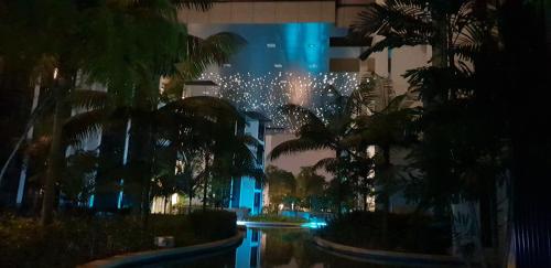 a building with a bunch of palm trees and lights at MCity Jalan Ampang KLCC in Kuala Lumpur