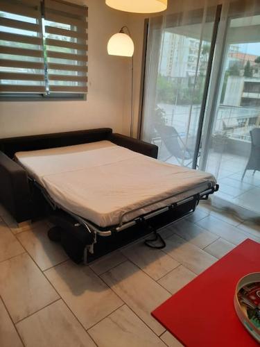 un lit d'hôpital dans une chambre avec fenêtre dans l'établissement Studio Croix des Gardes Palais Plages, à Cannes