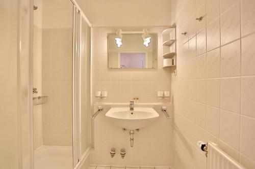 y baño blanco con lavabo y ducha. en Seesternresidenz Seesternresidenz Appartement 8 en Scharbeutz