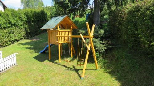 a playground in a yard with a small house at Pension Jana - Wellness in Jilemnice