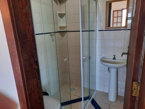 a bathroom with a sink and a glass shower at Pousada Icthus in Cabo Frio