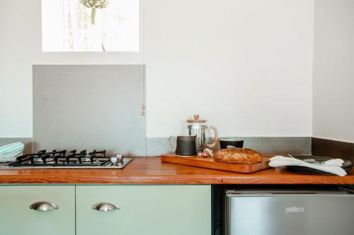 a kitchen counter with a stove and a tray of bread at The Ley @ The Sea in Kalk Bay