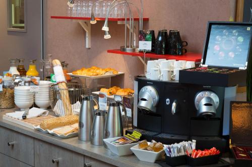 a counter with a buffet with food on it at Mercure Strasbourg Aéroport in Ostwald