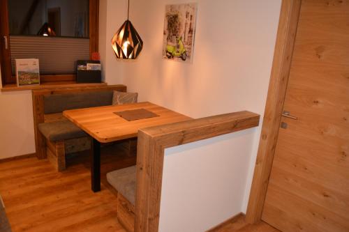 a dining room with a wooden table and a door at Ramseiderhof in Saalfelden am Steinernen Meer
