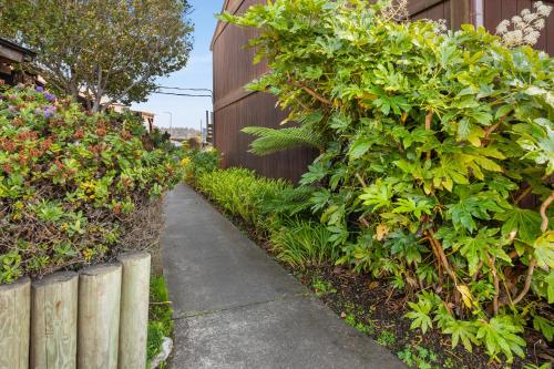 a garden path next to a fence with plants at Harbor Lite Lodge in Fort Bragg
