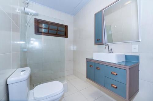 a bathroom with a toilet and a sink and a mirror at Recanto da Conceição in Bombinhas